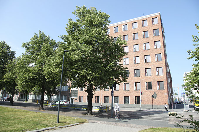 Korkea punatiilinen kerrostalo Oulun keskustassa.